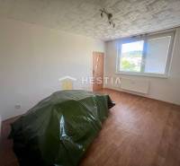 An empty room in a 3-room apartment with a window, door, and green foil on the floor.