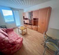 Living room in a 3-room apartment with a sofa, table, and wardrobe, light flooring.
