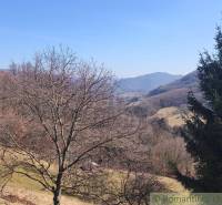 Landscape in Nová Baňa with a view of hills and trees in gardens.