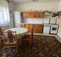 Kitchen in a family house with a dining table, wooden cabinets, and a gas stove.
