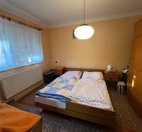 Bedroom in a family house with two beds, a wardrobe, and a carpet.