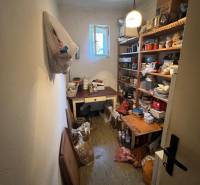 Storage space in a family house with shelves full of various items and an open window.