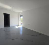 Spacious room in the villa with white walls and a floor with a wooden decor.