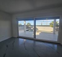 Interior of a villa with large glazing and a view of the exterior with a pool.