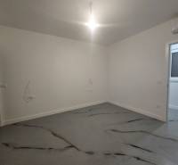 An empty room in a villa with concrete floor decor and white walls.
