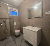 Bathroom in the Villa with a toilet, shower, and sink, flooring with a stone pattern.