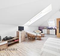 An attic room in a family house with armchairs and a wooden decor floor.