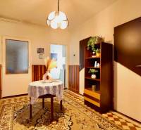 Interior of a family house with carpet flooring, a cabinet and lighting in the background.