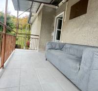 The terrace of a family house in Pruské with a sofa and a view of greenery.