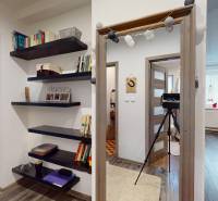 Interior of a family house with an open passage, bookshelf, and wooden floor decor.