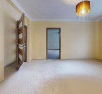 A bright room in a family house with curtains, a chandelier, and open doors.