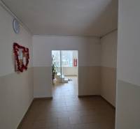 A hallway with white walls and light tiles in a 3-room apartment.