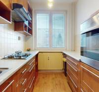 A kitchen in a 3-room apartment with a gas stove and a floor with a wood decor.