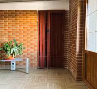 Interior with a brick wall and a plant, floor with wooden decor in a 3-room apartment.