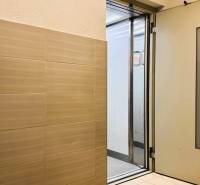 Interior with an elevator and a tiled wall in a 3-room apartment.