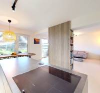 Open interior of a family house with a kitchen, dining area, and comfortable living corner.