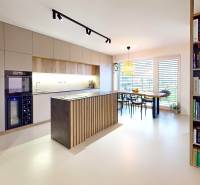 Open kitchen with dining table and bookshelf in a family house.