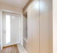 Entrance hallway of a family house with a coat closet, mirror, and carpet.