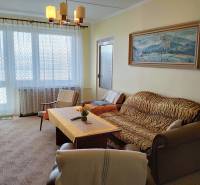 Living room with a sofa, armchair, and table in a 2-room apartment with a large window.