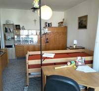 A room in a 2-bedroom apartment with furniture, a bed, and decorations on the shelves.