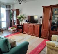 Living room in a two-room apartment with a wooden decor floor and comfortable furniture.