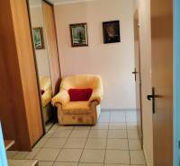 An armchair by the entrance door with a tiled floor in a 2-room apartment, mirrored wardrobe.