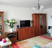 Living room in a two-room apartment with wooden decor and a light interior.