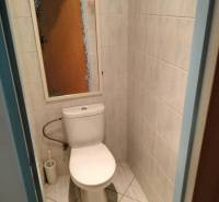 Bathroom with tiles and toilet in a 2-room apartment.