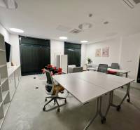 An office with white furniture, two desks, and shelves in a two-room apartment.