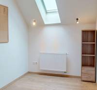 An office with a wooden decor floor, a wall board, and a shelf.