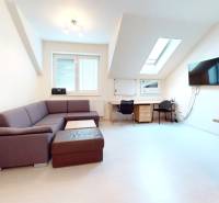 Offices with wood-patterned flooring, a desk, a sofa, and a screen on the wall.