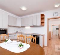 Dining room in a 3-room apartment with a kitchen unit and a wooden decor floor.