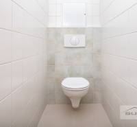 A toilet with tiles and a wall-hung toilet in a 3-room apartment.