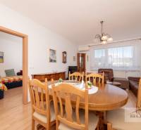 Dining table with wooden chairs in a 3-room apartment, next to the living room.