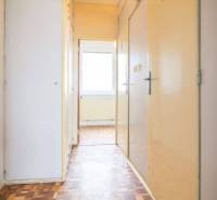 A hallway in a 2-room apartment with a parquet floor and built-in wardrobes.