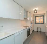 A bright kitchen with modern appliances in a two-room apartment, floor with wooden decor.