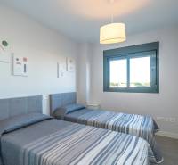 Two single beds in a 2-room apartment with a window and decorative paintings on the wall.