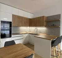 A kitchen in a 2-room apartment with a wooden decor floor and wooden details.
