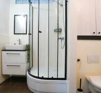 Bathroom in a 3-room apartment with a washing machine, shower, and toilet.