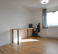 A room with a computer desk and a floor with a wooden decor in a 3-room apartment.