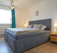 Bedroom in a 3-room apartment with a bed, nightstands, and a floor with a wood decor.