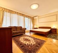 Bedroom in a 4-room apartment with a wooden decor floor and elegant furniture.