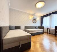 A room in a 4-room apartment with two beds, air conditioning, and a wooden decor floor.