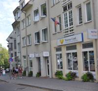 The building with a travel agency office on Zámocká in Bratislava, a group of people on the sidewalk.