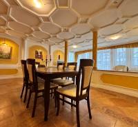 A dining room with a stucco ceiling, decorative paintings, and a wooden table, 4-room apartment.