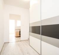 Interior of a 2-room apartment with a wooden decor floor and a built-in wardrobe.