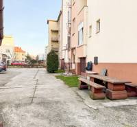 Parking and a bench in front of the building on Hodžova Street in Trenčín, near the 2-room apartment.