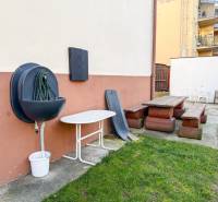 A garden on Hodžova Street in Trenčín with a bench and garden furniture near a 2-room apartment.