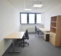 Offices with two desks and chairs, gray carpet, shelf.