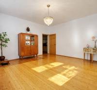 A family house with a chandelier, a wardrobe, and a wooden-decor floor in a spacious living room.